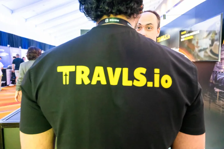 The Travls wordmark on a team member's shirt at TOKEN2049 Singapore