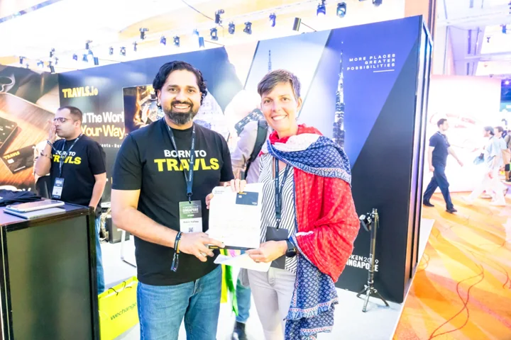 A guest and Travls team member at the Singapore conference booth