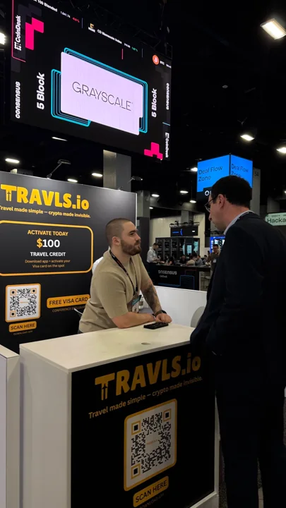 A visitor talking to the team at the Travls Consensus Miami stand