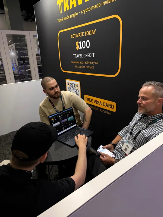 Travls team demonstrating the platform during a booth conversation in Miami