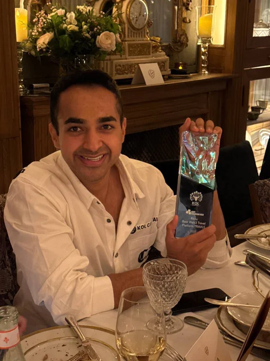 A Travls representative holding the KOL Capital Award in Paris