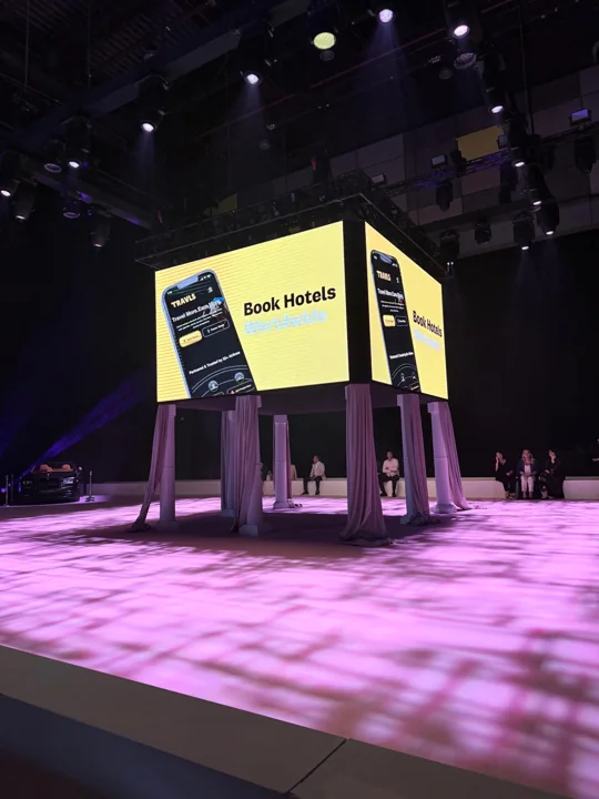 A Travls travel feature displayed on a stage screen at DJFW Dubai