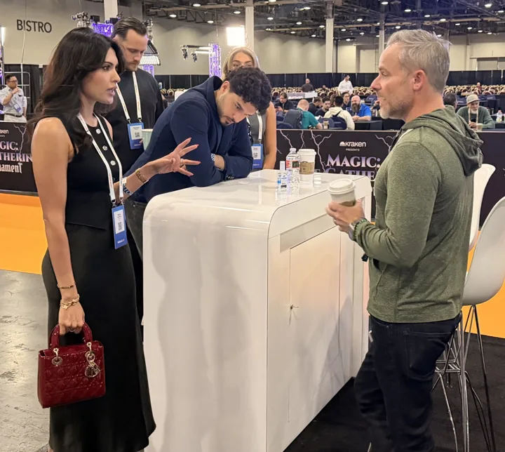 Guests in conversation around the Travls booth counter at BTC Vegas